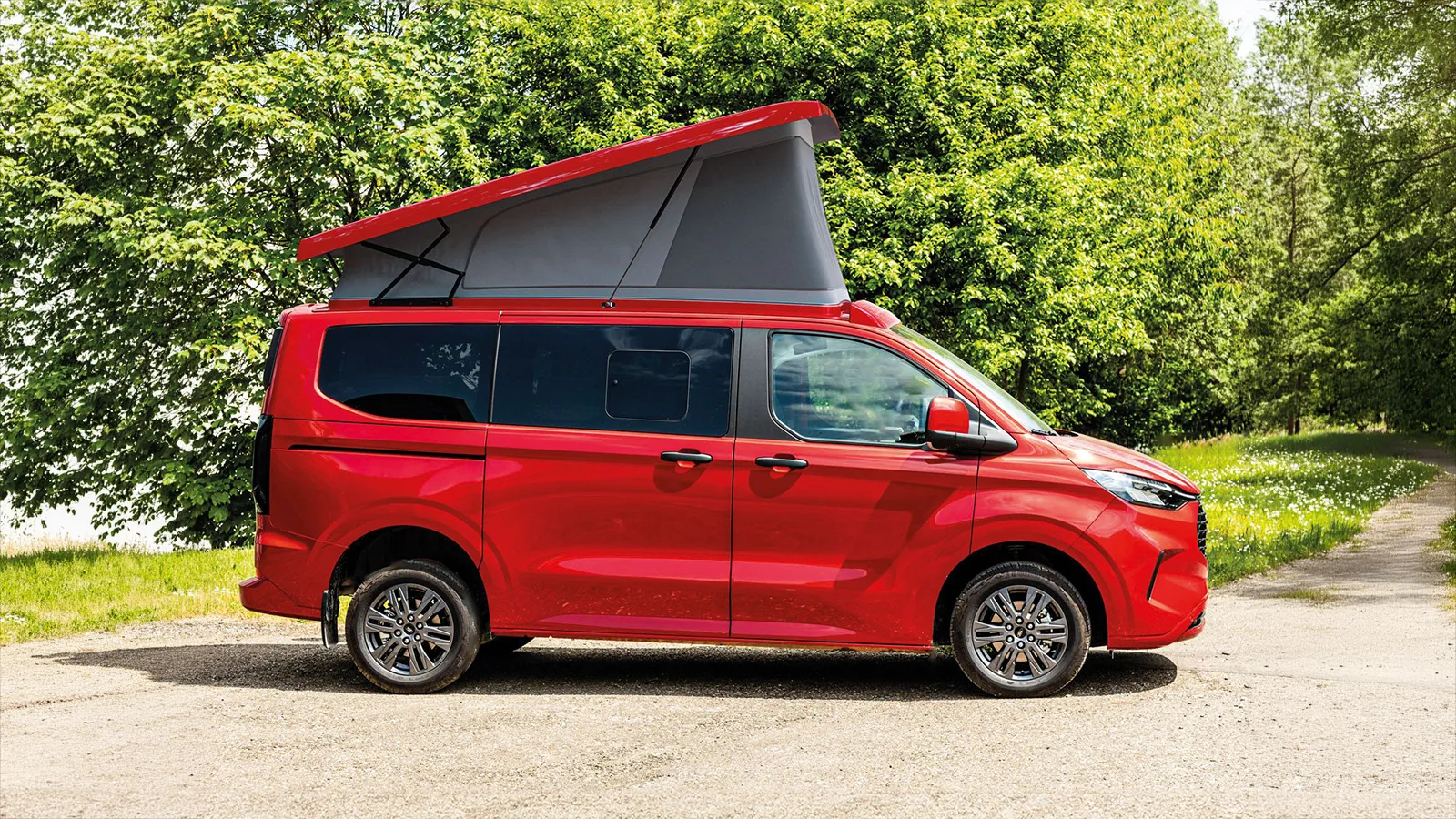 Ford Campervan mit Aufstelldach SCA 324 in Rot, geöffnetem Dach und Panoramablick in den Bergen – ideal für Vanlife und Campingausbau.