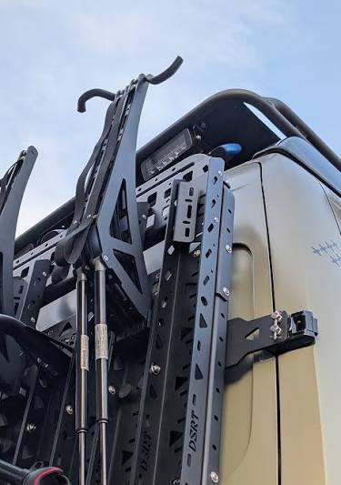 Bis zum Boden abgesenkter elektrischer Bikelift an der Heckwand eines Wohnmobils zur einfachen Beladung von E-Bikes.