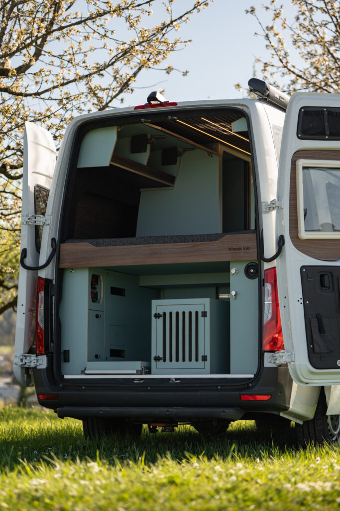 Massgeschneiderte und crashsichere Hundebox im Heck eines Vans als professioneller Camperausbau Hund von Biwak Lab.
