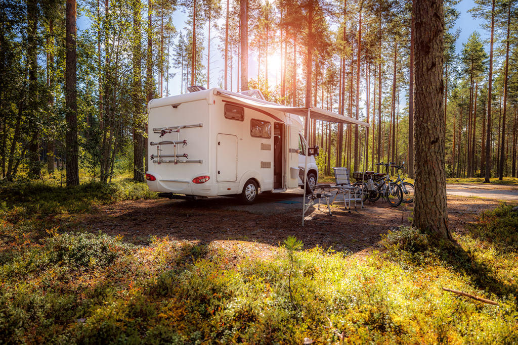 Ausgebauter Camper Van mit professionell montierter Markise und gemütlichem Sitzbereich im Freien vor der Werkstatt von biwak lab.